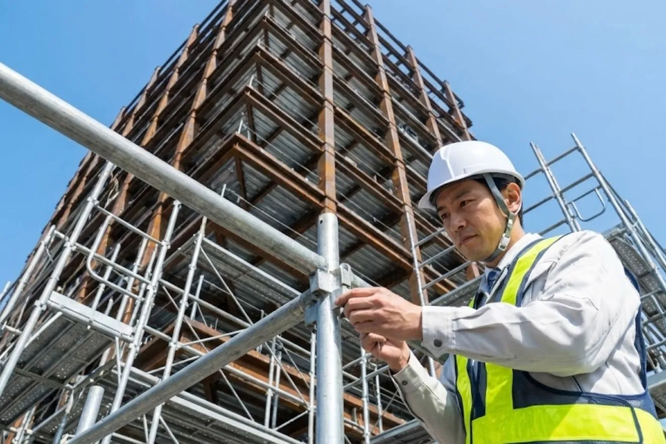 建設現場でヘルメットを着用し安全点検を行う作業員の様子